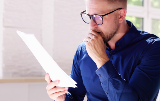 man wearing glasses and reading his paper