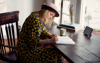 Woman editing her paper at a desk to help show What Comes After Your First Draft Is Done