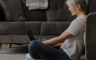 woman sitting on the floor working on her laptop to help portray the message of the blog Stop Optimizing for Sales: Why I'm Done Chasing Amazon Metrics