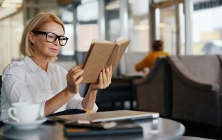 Woman reading a book to help illustrate What "Trust the Reader" Actually Looks Like on the Page